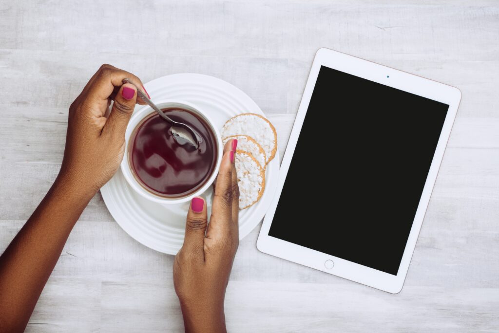 Conheça a ferramenta BibliON. A imagem da arte apresenta uma pessoa com um tablet e um café. 